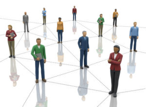A group of people standing around a network of people.