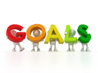 A group of 3d people holding up the word goals.