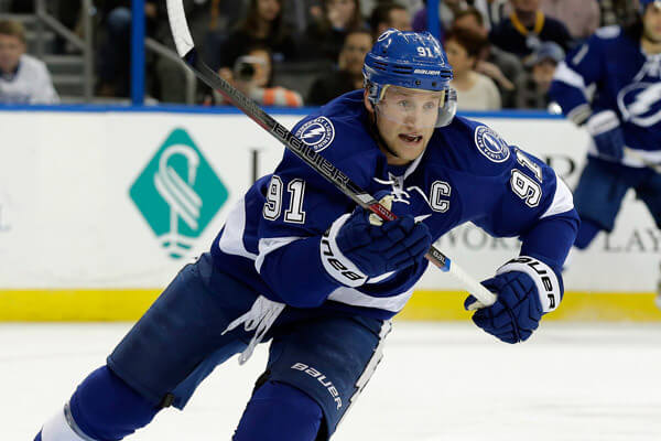 A tampa bay lightning player is running with the puck.