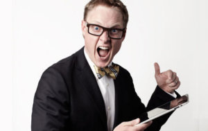 A man with glasses and a bow tie holding a tablet.