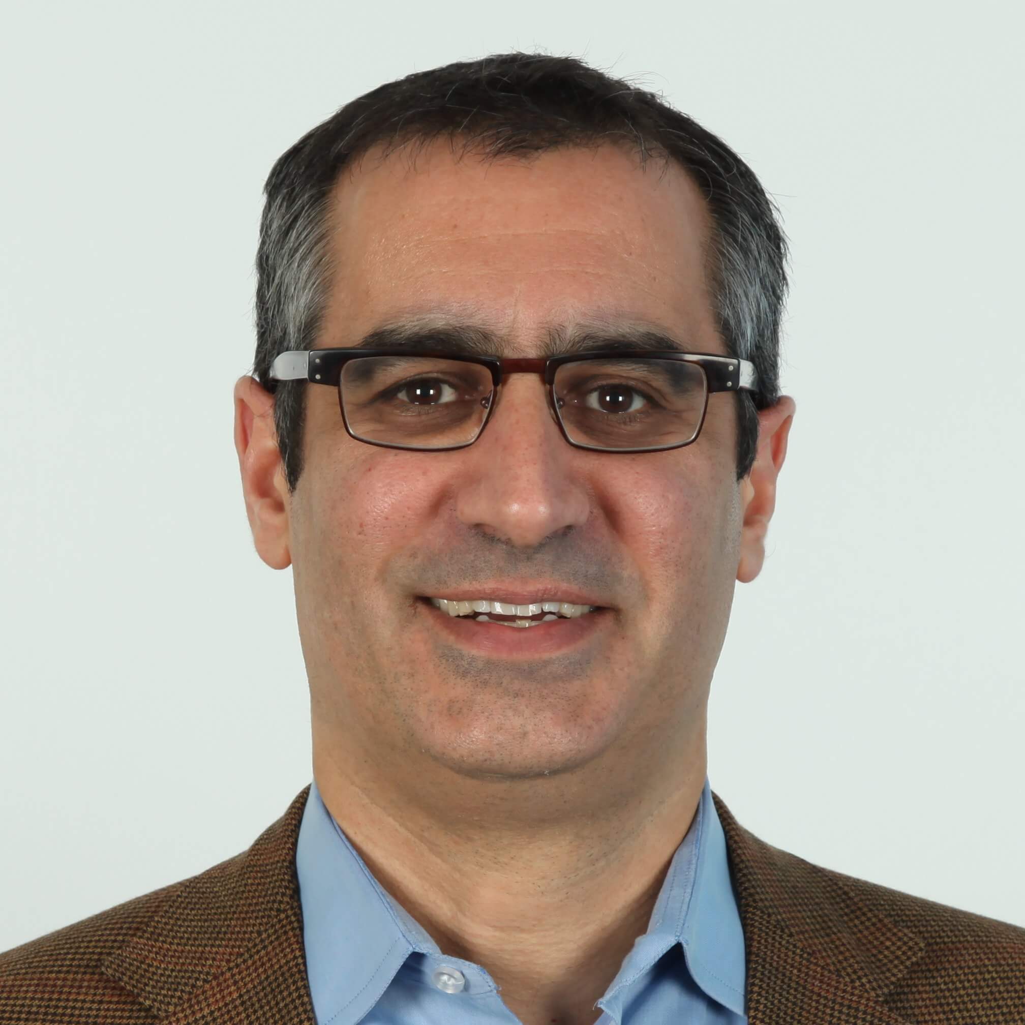 A man in glasses is smiling for the camera.