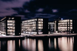 A large building next to a body of water at night.