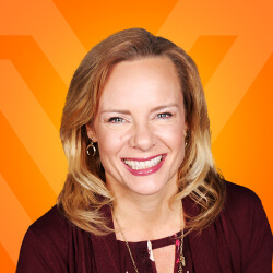 A woman utilizing a social selling strategy while smiling in front of an orange background.