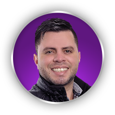 Luis Lopez posing with a smile against a purple backdrop.