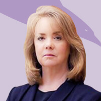 Our team's professional woman in a suit poses against a purple background.