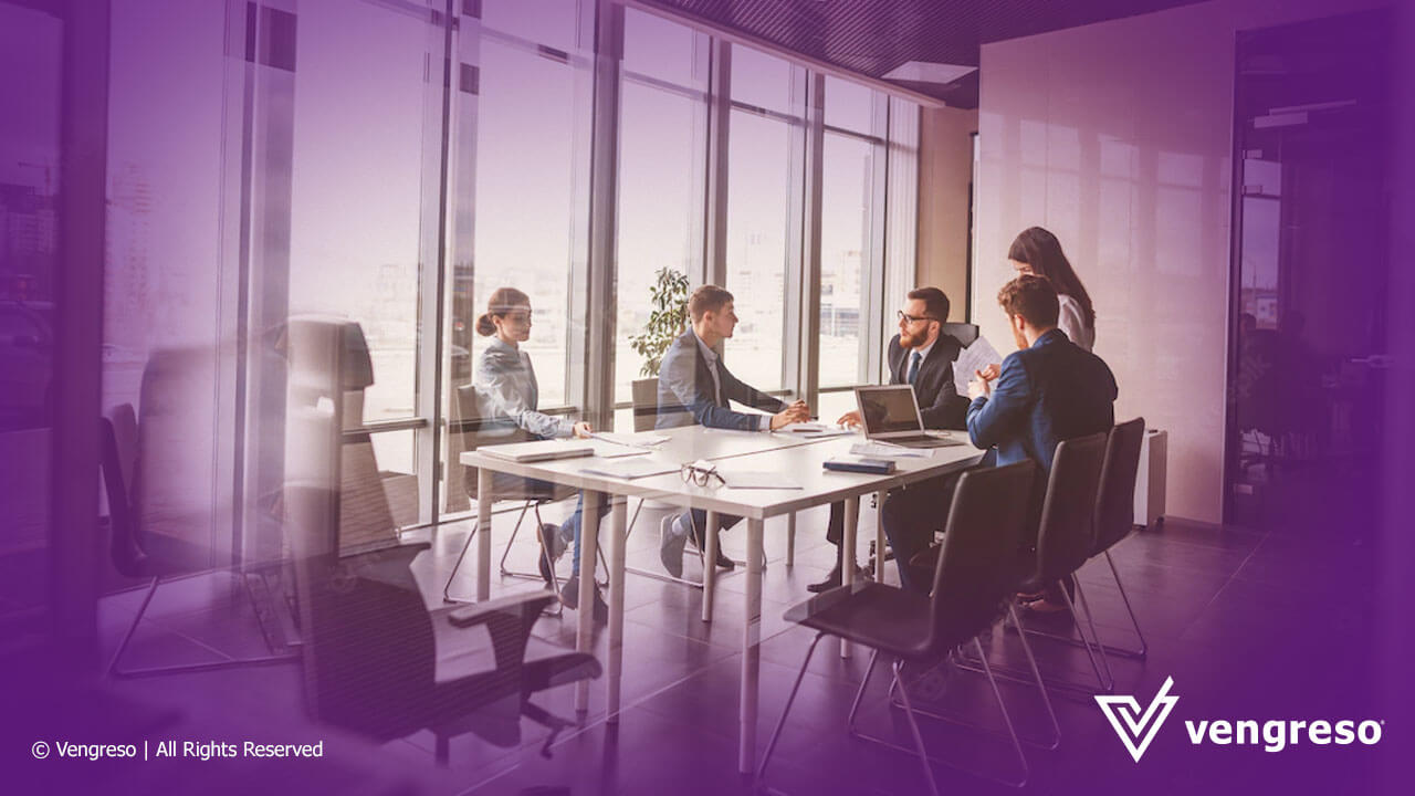 Sales enablement teams sitting around a table in a conference room.