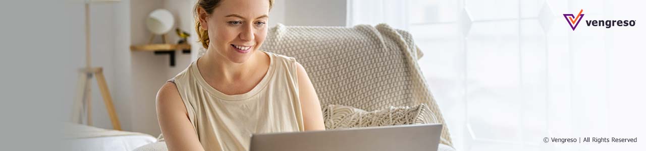 woman smiling sitting in front of computer writing thank you email