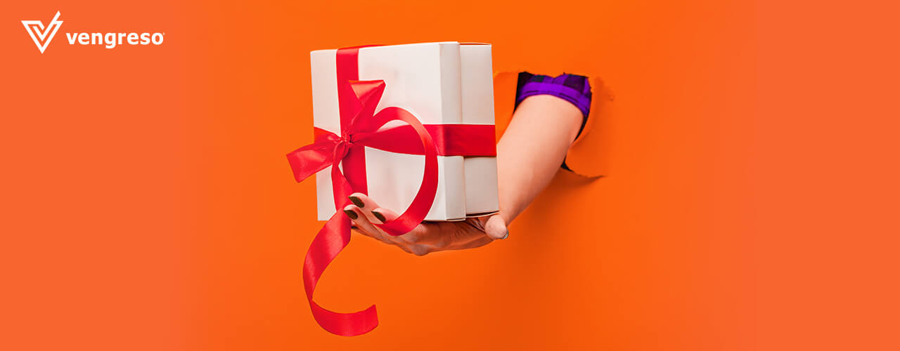 hand with a corporate gift breaking through an orange wall