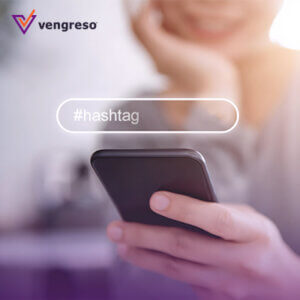 woman smiling looking at her phone with a search bar with the word hashtags in front of the image