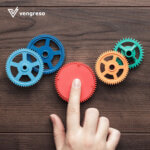 a hand touching many colored gears