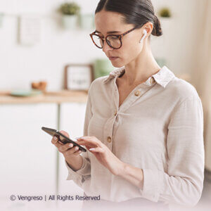 woman with glasses looking at her mobile phone for best writing apps