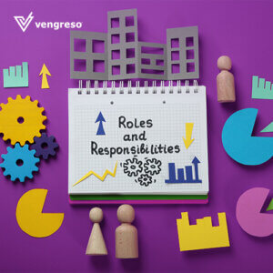 cut outs of gears and buildings and pie graphs set around a notebook with the words roles and responsibilities written on it