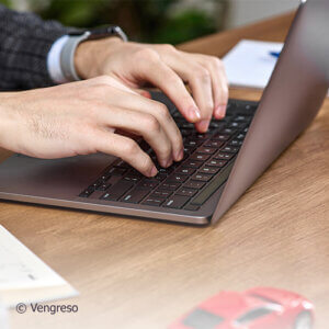 close up of hands typing on a keyboard writing an email requesting something