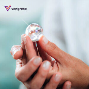 close up of two hands holding a small crystal ball