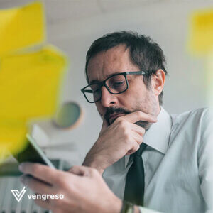 A man engrossed in his phone while surrounded by sticky notes.